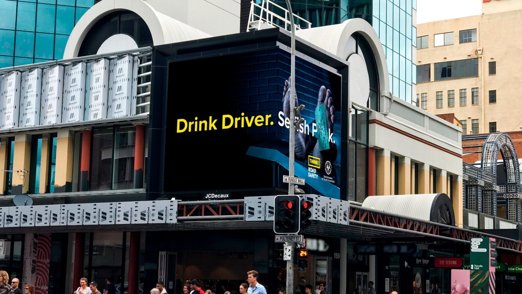 Dead person feet on street billboard for drink driving behaviour change campaign.