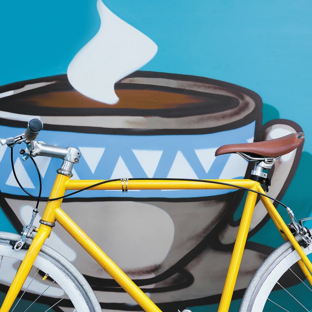 Yellow bike against mural for land development branding.
