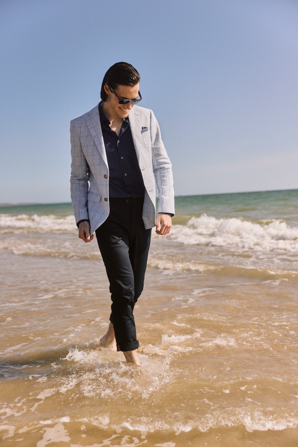Man in suit walking through ocean for TVC production.