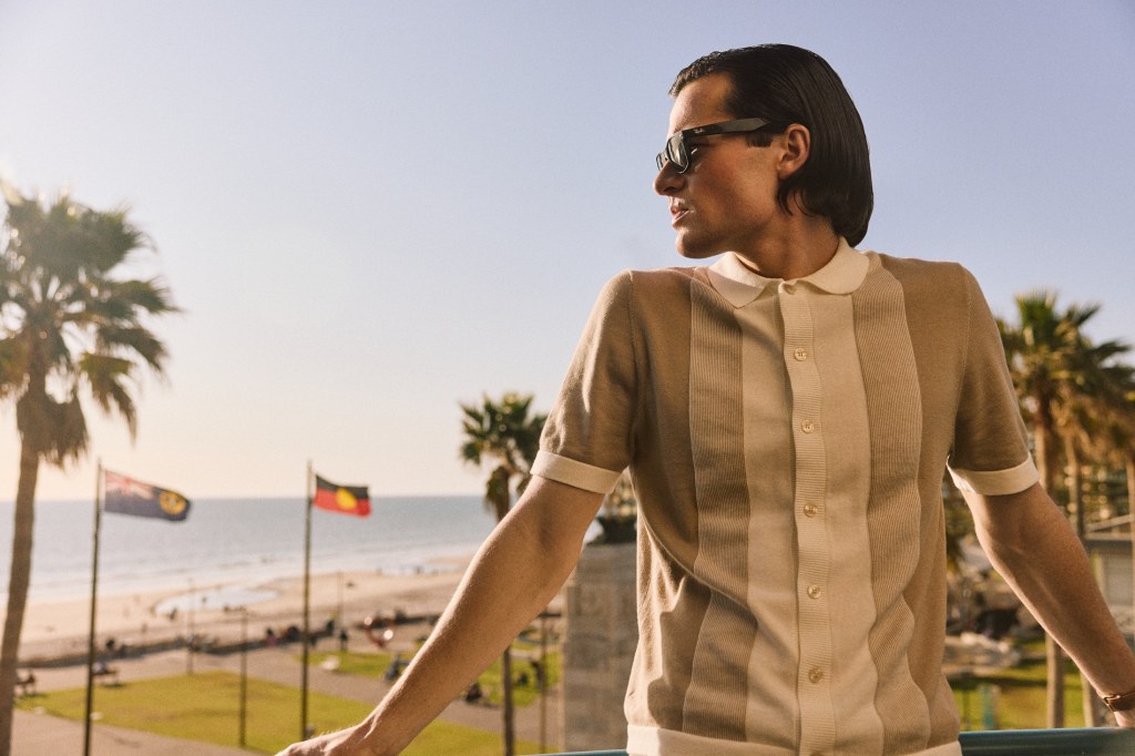 Man in casual polo shit looking at ocean for TV production.